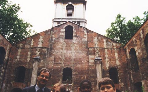 LSO Managing Director Clive Gillinson and local children, pictured in the overgrown centre of St Luke's Church before restoration