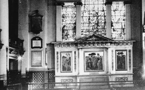 The interior of St Luke's Church before deconsecration, showing the altar and stained glass windows